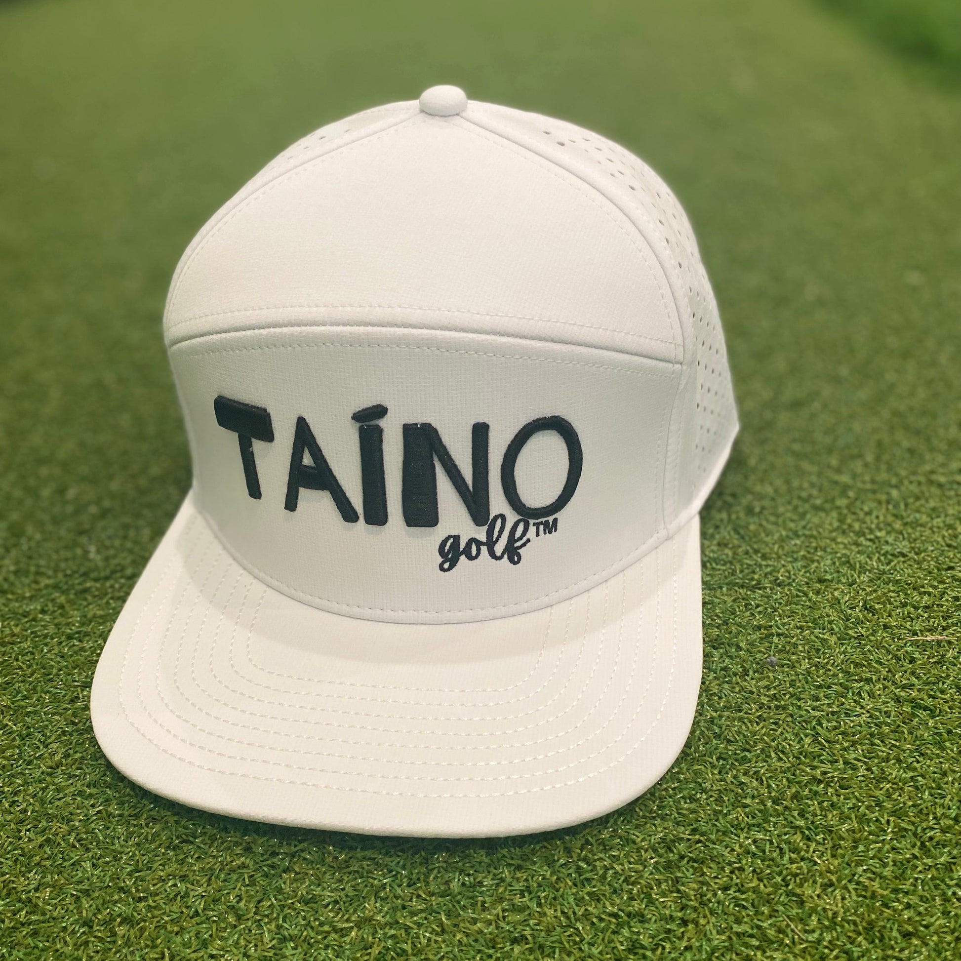 Waterproof Taino Golf hat in white, designed to protect golfers from sun and rain while maintaining breathability and comfort, featuring the Taino Golf logo in black on the front.